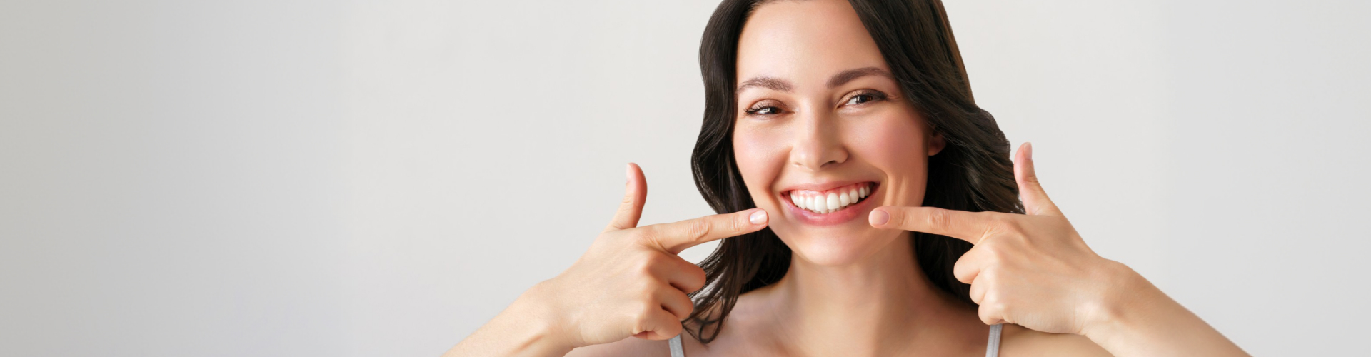 Woman smiling confidently with a beautiful smile enhanced by a cosmetic smile makeover.